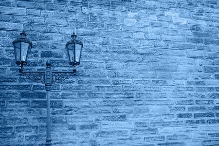 A lantern against a brick wall in trendy classic blue.の写真素材