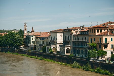 View of traditional residential buildings along the river promenade in Verona in Italyの写真素材