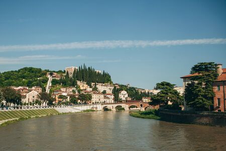 Beautiful view of traditional architecture and a bridge over a river in Verona in Italy.の写真素材