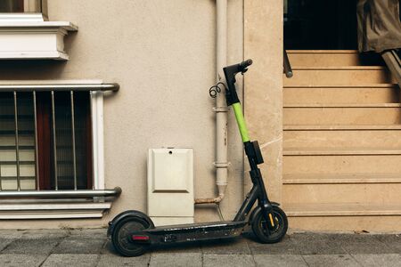 An electric scooter is parked at the entrance to a residential building