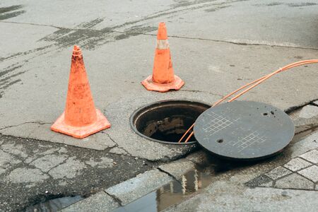 Repair work on troubleshooting or communal service work. Open iron hatch with cable going inside.の写真素材