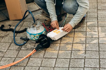 A plumber or utility worker repairs a broken water pump on the street. The work of municipal utilities.の写真素材
