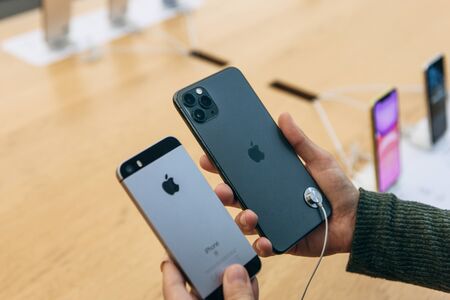 Turkey, Istanbul, December 17, 2019: The buyer compares the camera on the old iPhone and the latest modern iPhone 11 pro max in the Apple store.のeditorial素材