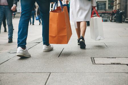 People with bags after shopping walk down the street.の写真素材