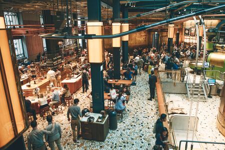 Italy, Milan, May 30, 2019: People, tourists and coffee lovers at Starbucks Reserve in Milan. The interior of the coffee shop.