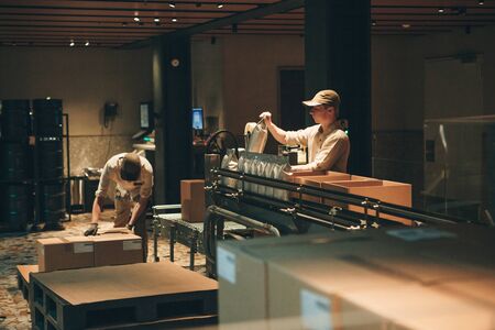 Italy, Milan, May 30, 2019: Conveyor for packing coffee beans at Starbucks Reserve in Milan. The technological process with employees.のeditorial素材