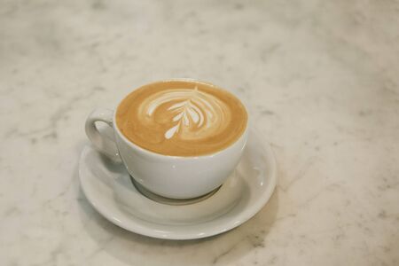 A cup of fresh tasty cappuccino coffee on a marble table.の写真素材