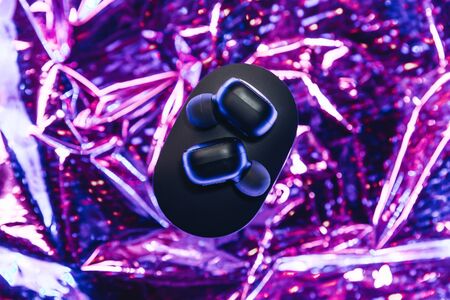Wireless headphones on a trendy neon color gradient background.の写真素材