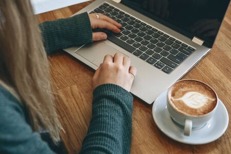 Student girl studying or freelancer working on a laptop in a cafe or coworking.の写真素材