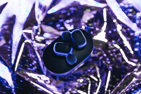 Wireless headphones on a trendy neon color gradient background.の写真素材