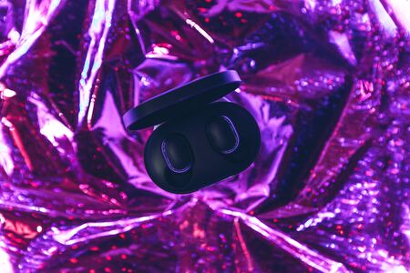 Wireless headphones on a trendy neon color gradient background.