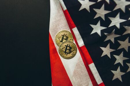 Bitcoin cryptocurrency coins next to american flag background.の写真素材