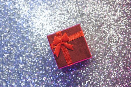 Red gift box on a shiny or glittering background. Holiday conceptの写真素材