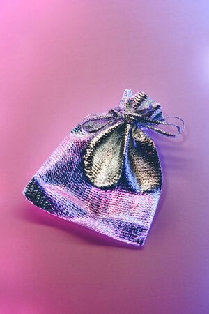 Silver small gift bag on a gradient background illuminated by neon light.の写真素材