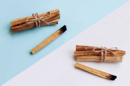 Palo Santo sticks on a white and blue background. They are used in aromatherapy and religious rites and meditations.の写真素材