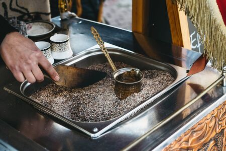 Making traditional black Turkish coffee or espresso in the sand in a special Turk.の写真素材