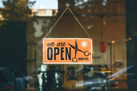 Georgia, Tbilisi, February 25, 2020: Retro signboard We are open barber shop at the entrance to the...