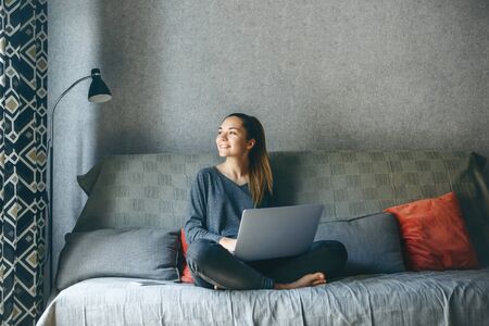 Girl working on laptop from home or student studying from home or freelancer. Or she is watching a video or using the Internetの写真素材