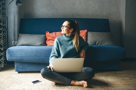 Girl working on laptop from home or student studying from home or freelancer. Or she is watching a video or using the Internetの写真素材