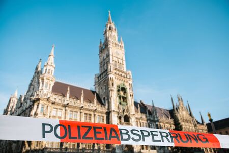 Police tape labeled Police Cordon at the Marienplatz in Munich. The concept of banning visits to public places during the epidemic of the coronavirus COVID-19.の写真素材