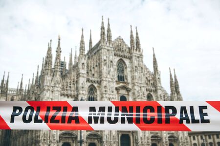 Police tape with the inscription Municipal Police on the background of the Duamo in Milan. The concept of banning visits to public places during the epidemic or pandemic of the coronavirus COVID-19の写真素材