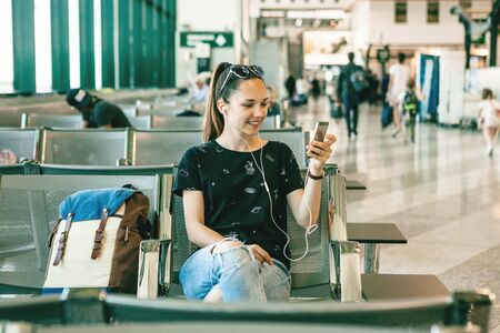 Girl tourist or student talking on video chat or video call while waiting for a flight at the airport.の写真素材