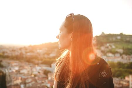 Portrait of a beautiful young girl enjoying sunset with her eyes closed.の写真素材