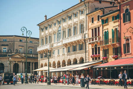 Italy, Verona, June 01, 2019: View of the city square with ancient European architecture with street cafes with many people.のeditorial素材