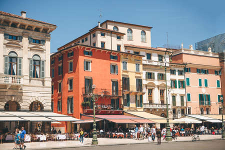 Italy, Verona, June 01, 2019: View of the city square with ancient European architecture with street cafes with many people.のeditorial素材