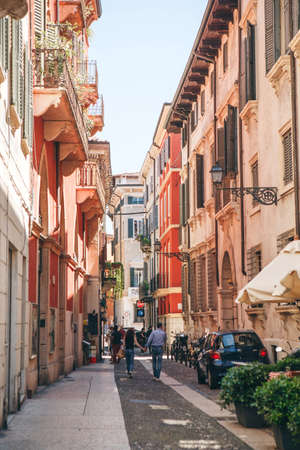 Italy, Verona, June 01, 2019: Traditional old street. Locals and tourists walk or walk along a city street. They go sightseeing or go about their daily business.のeditorial素材