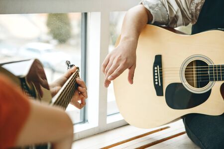 Learning to play the guitar. The teacher explains to the student the basics of playing the guitar. Individual home schooling or extracurricular lessons.の写真素材