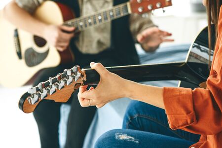 Learning to play the guitar. The teacher explains to the student the basics of playing the guitar. Individual home schooling or extracurricular lessons.の写真素材