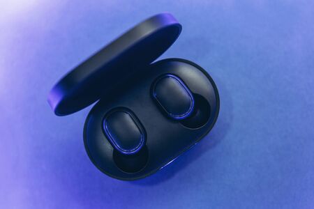 Wireless headphones on a trendy neon color gradient background.の写真素材