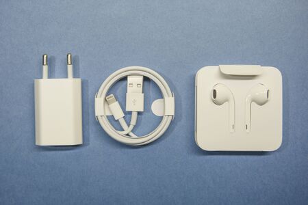 A set of accessories for a cell phone. Headphones and charger with wire.の写真素材