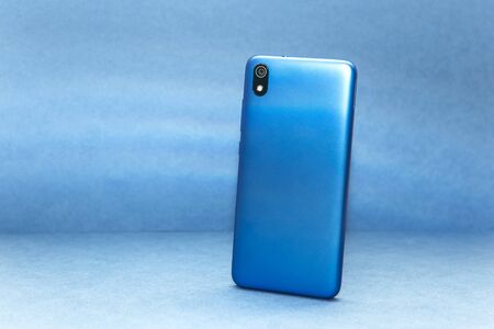 Rear view cell phone with camera on a blue background.の写真素材