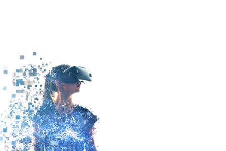 A girl in virtual reality glasses is pixelated or scattered into pixels. VR concept. Modern technologies.の写真素材