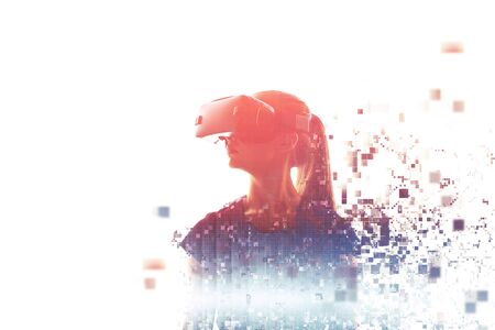 A girl in virtual reality glasses is pixelated or scattered into pixels. VR concept. Modern technologies.の写真素材
