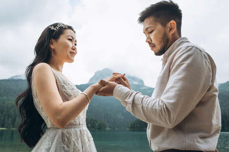 The Kazakh groom puts on a wedding ring on the finger of the Kazakh bride.の写真素材