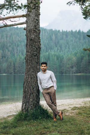 Portrait of a handsome positive young Kazakh man on the background of the lakeの写真素材