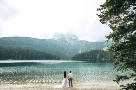 A young wedding couple admires the beautiful view of the lake in Montenegro.の写真素材