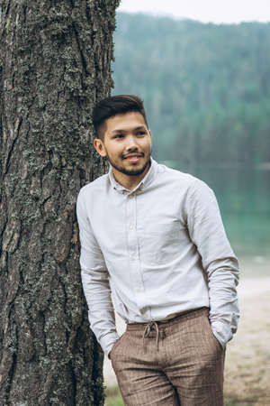 Portrait of a handsome positive young Kazakh man on a background of nature.の写真素材