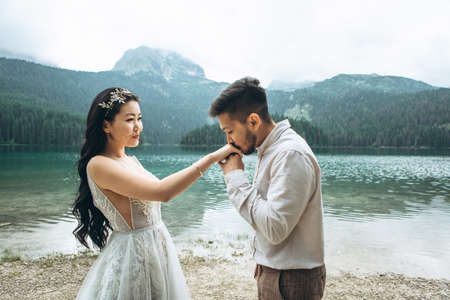 Kazakh groom gently kisses the hands of his brideの写真素材