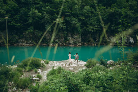 A man leads a womans hand on a background of a beautiful view of the river.の写真素材