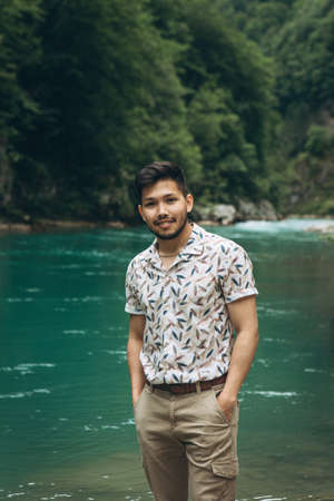 Portrait of a handsome positive young Kazakh man on a background of nature.の写真素材