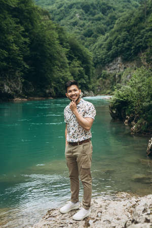 Portrait of a handsome positive young Kazakh man on a background of nature.の写真素材