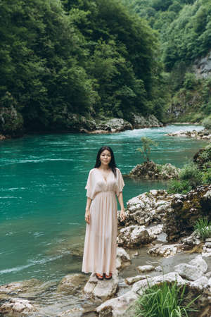 A young adult beautiful Kazakh girl on the river bank on a background of nature.の写真素材