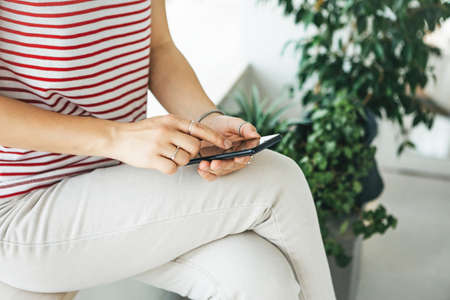 Close-up of hands - a girl is using a cell phone or mobile phone.の写真素材