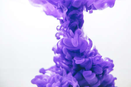 Purple color ink in water on a white background.の写真素材