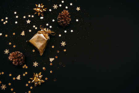 Various festive items and decorations in gold color on a dark or black background. Nearby space for text or copy space. Christmas or New Years concept.の写真素材