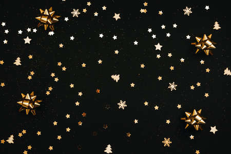 Festive dark background with many golden Christmas and New Year decorations and stars.の写真素材